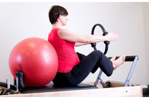 a women is using reformer pilates at home